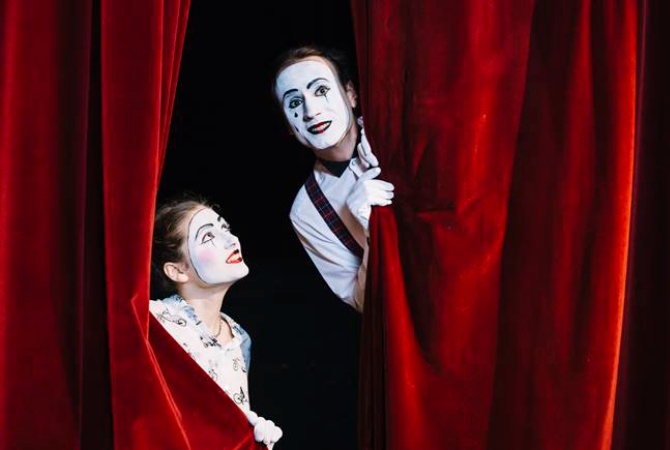 Imagem de 2 palhaços olhando através da cortina de 1 teatro